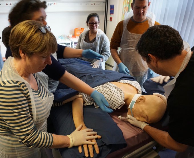 A group of men and women working on a dummy in a healthcare simulation centre