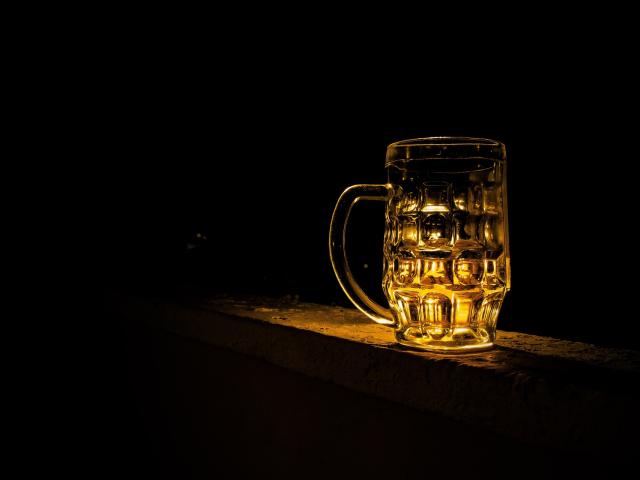 A lit-up pint glass against a dark background
