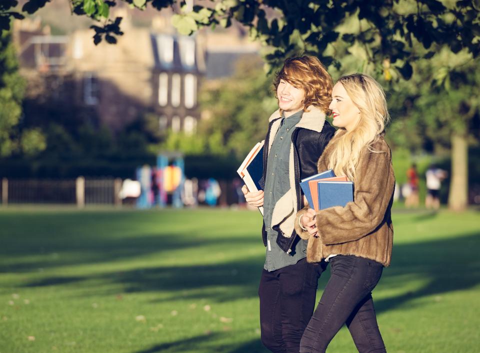 A male student and female student walking through the grounds of a university