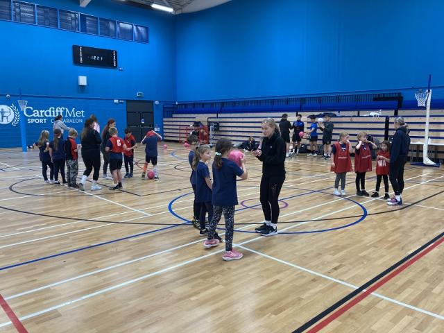 Children receiving netball coaching in a Cardiff Met sports hall